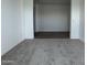 Open flex space with neutral carpeting and view of the wood-look tile flooring in the hallway at 15762 W Cheryl Dr, Waddell, AZ 85355