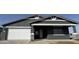 A home's exterior with a grey stucco facade, a two-car garage, a stylish white trim, and a covered porch at 15762 W Cheryl Dr, Waddell, AZ 85355