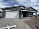 New construction home featuring a two car garage, gray exterior paint, and decorative gable accents at 15762 W Cheryl Dr, Waddell, AZ 85355