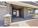 Welcoming covered front porch with stone accents, offering a charming entry to this lovely home at 15762 W Cheryl Dr, Waddell, AZ 85355