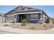 Inviting covered front porch with stone pillars and a well-maintained desert landscape at 15762 W Cheryl Dr, Waddell, AZ 85355