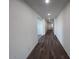 Long hallway with wood-look flooring and recessed lighting leads to the home's entrance at 15762 W Cheryl Dr, Waddell, AZ 85355