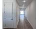 Bright hallway with wood-look flooring, recessed lighting, and views into the spacious living areas at 15762 W Cheryl Dr, Waddell, AZ 85355