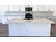 Large kitchen island with sink and white cabinets at 15762 W Cheryl Dr, Waddell, AZ 85355
