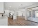 Bright, open living space featuring wood-look tile, sliding glass doors and an eat-in kitchen with white cabinets at 15762 W Cheryl Dr, Waddell, AZ 85355