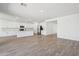 Bright, open living space featuring wood-look tile and eat-in kitchen with white cabinets and stainless appliances at 15762 W Cheryl Dr, Waddell, AZ 85355