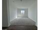 Spacious carpeted living room with a window offering views of the neighborhood at 15762 W Cheryl Dr, Waddell, AZ 85355