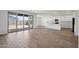 Bright, open living space featuring wood-look tile, sliding glass doors and an eat-in kitchen with white cabinets at 15762 W Cheryl Dr, Waddell, AZ 85355
