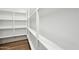 This pantry boasts ample shelving for optimal organization and wood-look floors at 15762 W Cheryl Dr, Waddell, AZ 85355