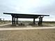 Open-air picnic shelter with multiple tables, providing a shady spot for community gatherings and meals at 15762 W Cheryl Dr, Waddell, AZ 85355