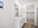 Bright bathroom featuring dual sinks, wood-look tile floors, and a large mirror at 15993 W Cottontail Ln, Surprise, AZ 85387