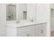 Close-up of a bathroom with dual sinks, modern faucets and hardware, and white cabinets at 15993 W Cottontail Ln, Surprise, AZ 85387