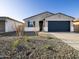 Charming single-story home featuring a gray stucco exterior, dark blue garage door and desert landscaping at 15993 W Cottontail Ln, Surprise, AZ 85387