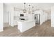 Modern kitchen featuring white cabinets, stainless steel appliances, and stylish pendant lighting over the island at 15993 W Cottontail Ln, Surprise, AZ 85387