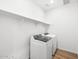 Bright laundry room featuring a modern, white, front-load washer and dryer at 15993 W Cottontail Ln, Surprise, AZ 85387