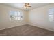 This bedroom features two windows with shutter-style blinds and carpeted floors at 16013 S Desert Foothills Pkwy # 2077, Phoenix, AZ 85048