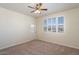 This bedroom features carpeted floors, a ceiling fan, and a bright window with shutter-style blinds at 16013 S Desert Foothills Pkwy # 2077, Phoenix, AZ 85048