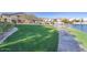 Expansive green space with a lake view, pedestrian walkway, lush landscaping, and an area for relaxing at 16013 S Desert Foothills Pkwy # 2077, Phoenix, AZ 85048