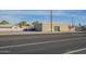 A view from the street shows the tan stucco exterior and the secure steel door of the commercial building at 1610 W Buckeye Rd, Phoenix, AZ 85007