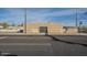 A side view of the tan stucco exterior shows a secure steel door of the commercial building across a city street at 1610 W Buckeye Rd, Phoenix, AZ 85007