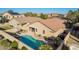 Aerial view of the backyard featuring a sparkling pool, covered patio, and a privacy fence at 16412 N 168Th Ln, Surprise, AZ 85388