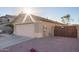 Exterior shot of a home featuring a two-car garage, manicured landscaping, and a paved driveway at 16412 N 168Th Ln, Surprise, AZ 85388