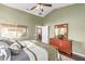 Bright main bedroom with a large window, wooden dresser, and a view into the connected living space at 16412 N 168Th Ln, Surprise, AZ 85388