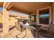 Relaxing covered patio featuring a dining table with seating and a grill, perfect for outdoor entertaining at 16412 N 168Th Ln, Surprise, AZ 85388