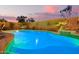 Gorgeous pool with verdant landscaping and ambient lighting at dusk at 16412 N 168Th Ln, Surprise, AZ 85388