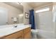 Well-lit bathroom with a white vanity, framed mirror, and a shower with a blue shower curtain at 16643 N 19Th St, Phoenix, AZ 85022