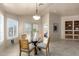 Bright dining room with a glass table, shuttered windows, and a view of the adjacent living spaces at 16643 N 19Th St, Phoenix, AZ 85022