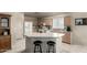 Well-lit kitchen with an island, bar seating, wooden cabinets, and modern white appliances in neutral colors at 16643 N 19Th St, Phoenix, AZ 85022