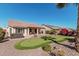 Spacious backyard with putting green, mature trees, and hot tub creates a relaxing outdoor oasis at 16713 W Monte Vista Rd, Goodyear, AZ 85395