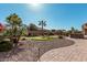 Landscaped backyard with a personal putting green, complemented by desert landscaping and a clear blue sky at 16713 W Monte Vista Rd, Goodyear, AZ 85395