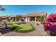 Beautifully landscaped backyard with a custom putting green and desert foliage for leisure and curb appeal at 16713 W Monte Vista Rd, Goodyear, AZ 85395