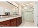 Primary bathroom featuring dual sinks, glass shower and walk-in closet at 16713 W Monte Vista Rd, Goodyear, AZ 85395