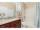 Bathroom features a shower and tub combo with neutral tile and cherry cabinets at 16713 W Monte Vista Rd, Goodyear, AZ 85395