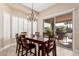 Elegant dining room features a modern chandelier, wood table with seating, and a sliding glass door to the patio at 16713 W Monte Vista Rd, Goodyear, AZ 85395