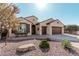 Lovely home with desert landscaping, seating on the porch, and a 3-car garage at 16713 W Monte Vista Rd, Goodyear, AZ 85395