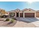 Charming home featuring a desert landscape, a brick walkway, and a three-car garage at 16713 W Monte Vista Rd, Goodyear, AZ 85395