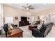 Comfortable living room with ceiling fan, patterned rug, dark leather sofas, and an entertainment center at 16713 W Monte Vista Rd, Goodyear, AZ 85395