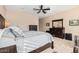 Bedroom includes wood furnishings, a ceiling fan, plush neutral carpet, and neutral-colored walls at 16713 W Monte Vista Rd, Goodyear, AZ 85395