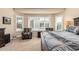 Well-lit bedroom showcasing plantation shutters, a ceiling fan, and a cozy seating area at 16713 W Monte Vista Rd, Goodyear, AZ 85395