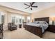 Spacious main bedroom features a ceiling fan, neutral carpet, plantation shutters, and a decorative accent wall at 16713 W Monte Vista Rd, Goodyear, AZ 85395