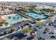 Aerial view of tennis courts, golf course, and parking in a well-maintained community at 16713 W Monte Vista Rd, Goodyear, AZ 85395