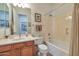 A bathroom featuring a sink with a wood cabinet, a toilet, and a shower with tan curtains at 1728 W Eagle Talon Trl, Phoenix, AZ 85085