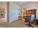 A home office with a built-in desk and a view of the hallway and bathroom at 1728 W Eagle Talon Trl, Phoenix, AZ 85085