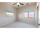 This carpeted bedroom has a ceiling fan and two large windows for ample natural light at 17441 W Rock Ledge Rd, Goodyear, AZ 85338