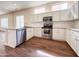 Bright kitchen features stainless steel appliances, wood floors, and white cabinetry at 17441 W Rock Ledge Rd, Goodyear, AZ 85338