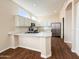 Charming kitchen offers white cabinets, stainless appliances, a subway tile backsplash and center island at 17441 W Rock Ledge Rd, Goodyear, AZ 85338